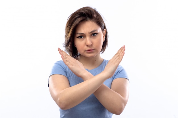 Young woman in blue shirt showing stop sign