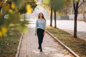 Free photo young woman in blue sweater in autumn park