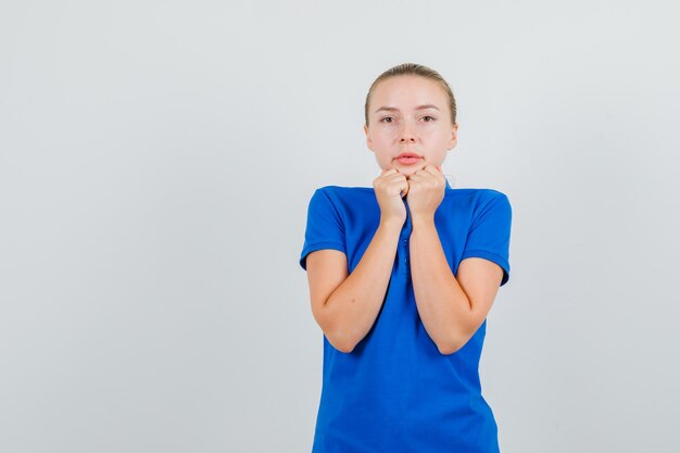 Foto gratuita giovane donna in t-shirt blu tenendo il collare e guardando