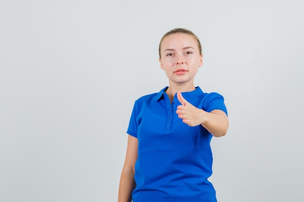Young woman in blue t-shirt stretching hand for shaking