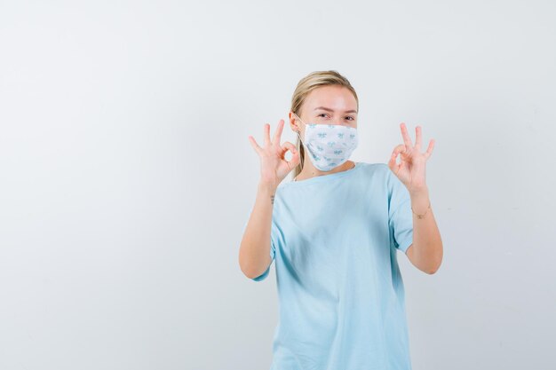 Young woman in a blue t-shirt with a medical mask