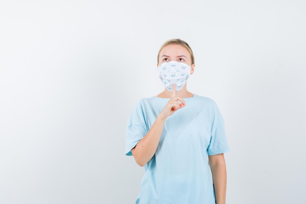 Free photo young woman in a blue t-shirt with a medical mask