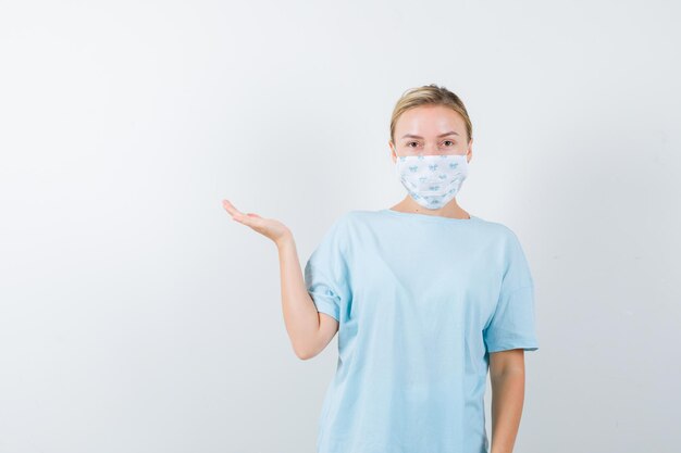 Young woman in a blue t-shirt with a medical mask