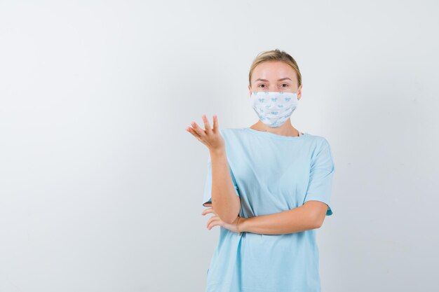 Young woman in a blue t-shirt with a medical mask