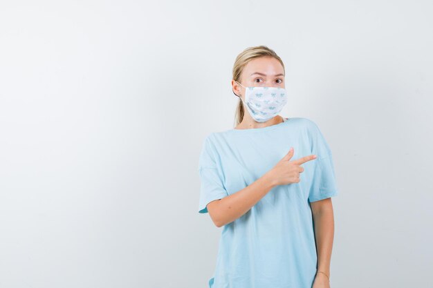 Young woman in a blue t-shirt with a medical mask