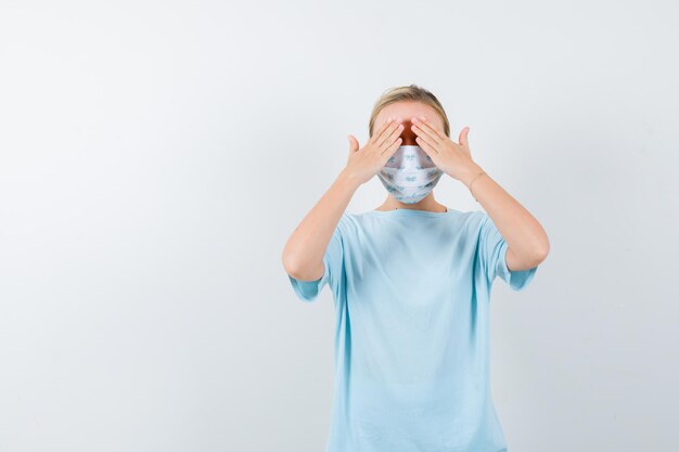 Young woman in a blue t-shirt with a medical mask