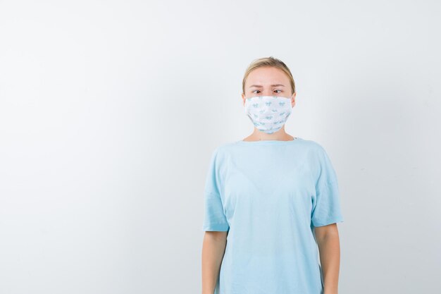 의료 마스크가 있는 파란색 티셔츠를 입은 젊은 여성
