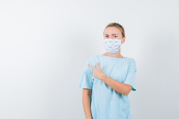 Young woman in a blue t-shirt with a medical mask