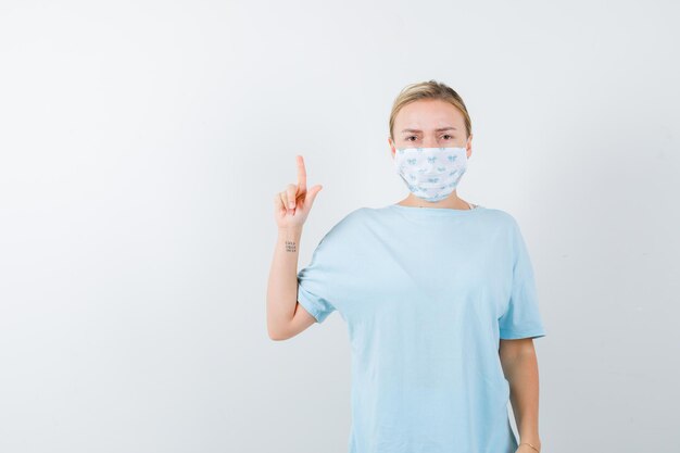 Young woman in a blue t-shirt with a medical mask