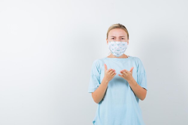 Young woman in a blue t-shirt with a medical mask