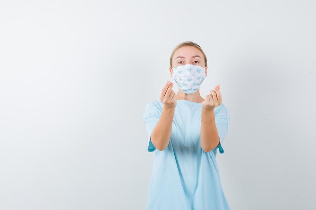 Young woman in a blue t-shirt with a medical mask