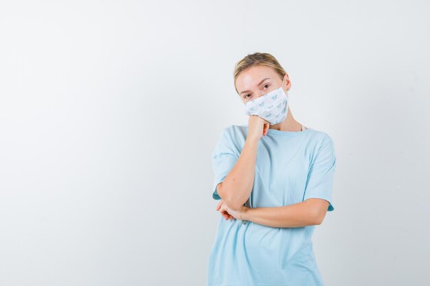 Young woman in a blue t-shirt with a medical mask