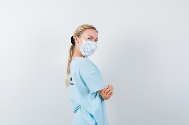 Young woman in a blue t-shirt with a medical mask