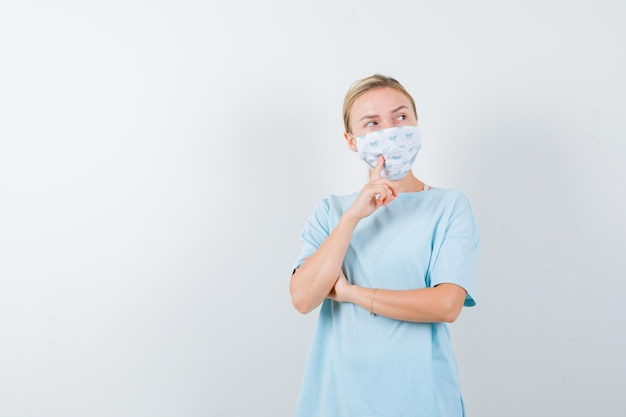 Young woman in a blue t-shirt with a medical mask