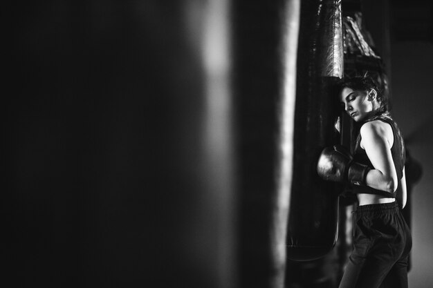 Young woman boxer training at the gym