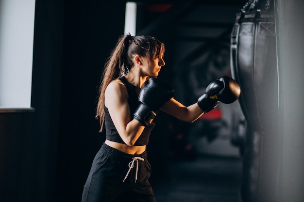 Young woman boxer training at the gym