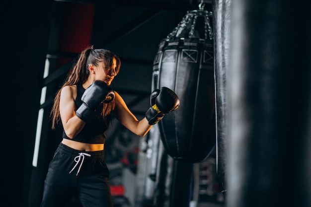 Free photo young woman boxer training at the gym