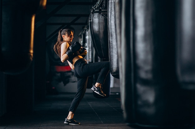 Free photo young woman boxer training at the gym