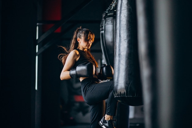 Free photo young woman boxer training at the gym