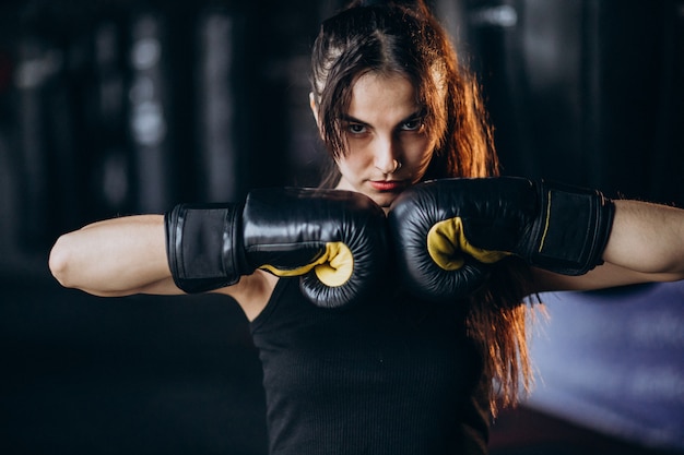 Young woman boxer training at the gym