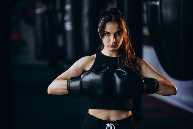 Young woman boxer training at the gym