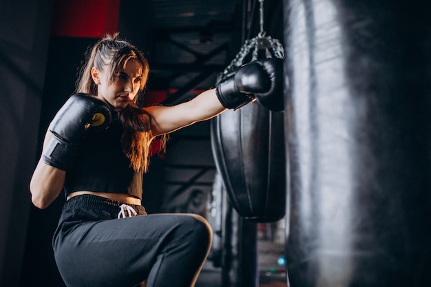 Free photo young woman boxer training at the gym