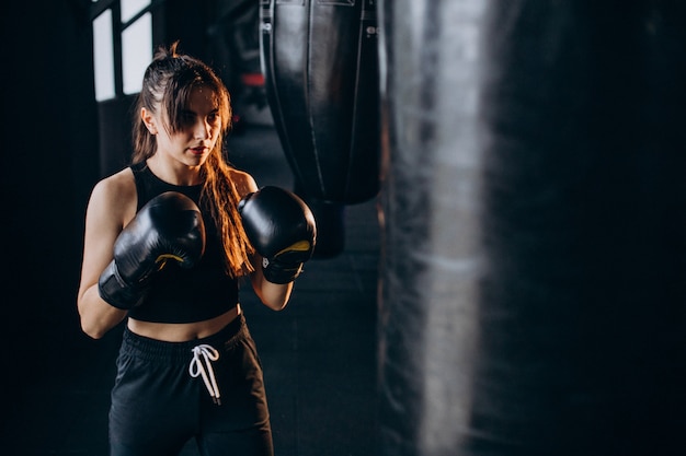 Young woman boxer training at the gym