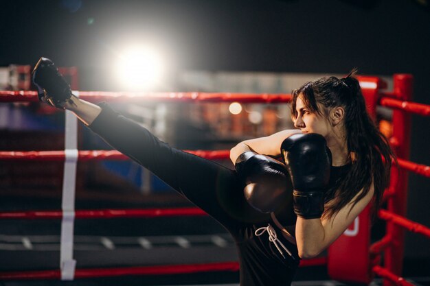 Young woman boxer training at the gym