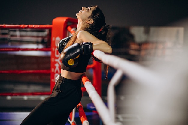 Young woman boxer training at the gym