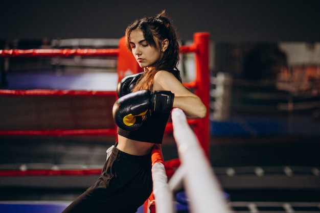 Young woman boxer training at the gym