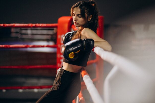 Young woman boxer training at the gym