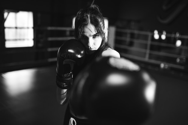 Young woman boxer training at the gym