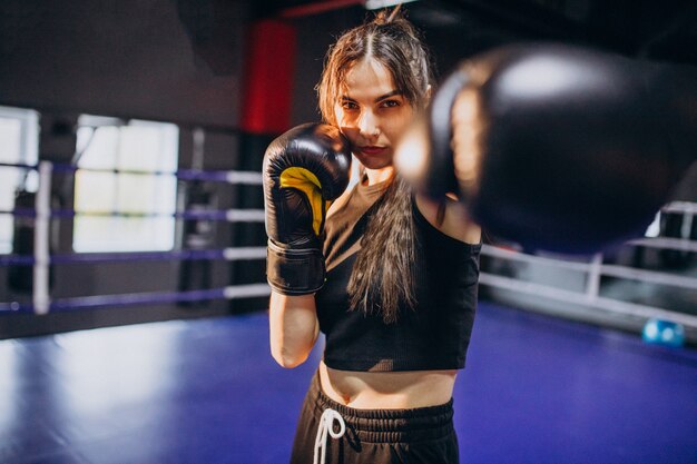 Young woman boxer training at the gym