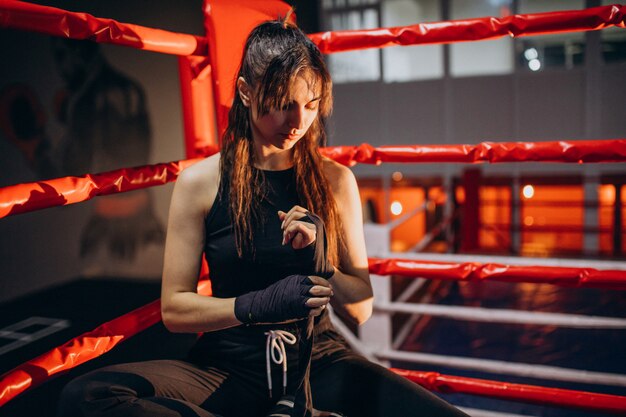 Young woman boxer training at the gym