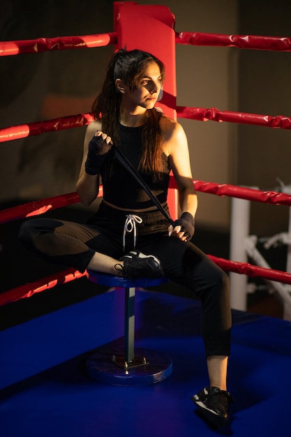 Young woman boxer training at the gym