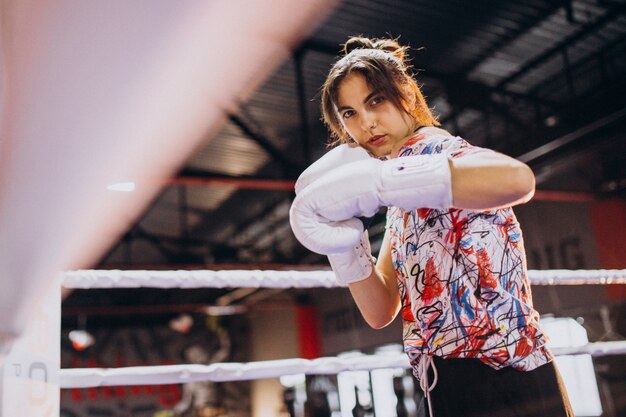 Young woman boxer training at the gym