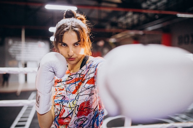 Young woman boxer training at the gym