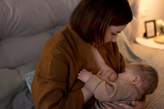 Young woman breastfeeding her cute baby