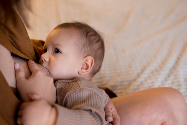 Young woman breastfeeding her cute baby