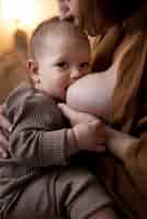 無料写真 彼女のかわいい赤ちゃんを母乳で育てる若い女性