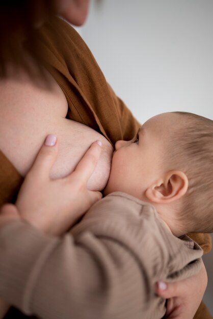 Young woman breastfeeding her cute baby