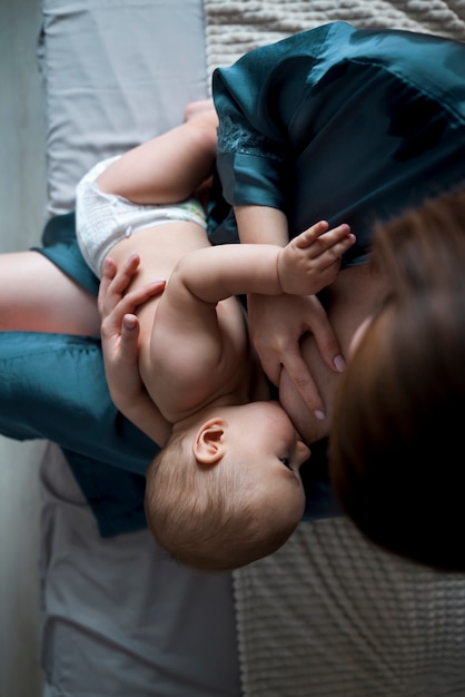 彼女のかわいい赤ちゃんを母乳で育てる若い女性