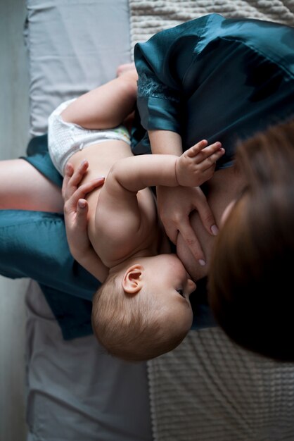 그녀의 귀여운 아기를 모유 수유 하는 젊은 여자