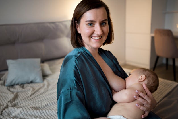 그녀의 귀여운 아기를 모유 수유 하는 젊은 여자