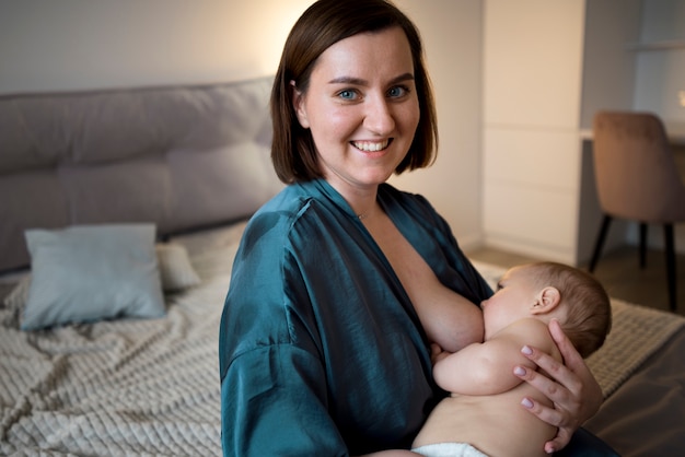 Young woman breastfeeding her cute baby