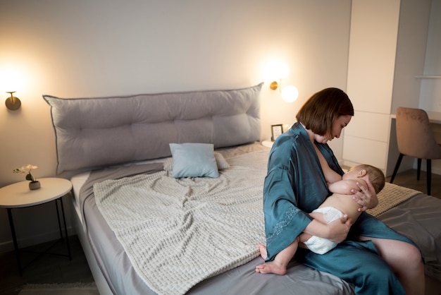 Young woman breastfeeding her cute baby