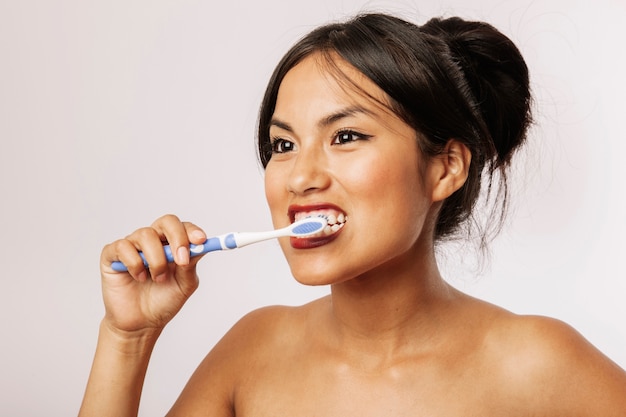 Free photo young woman brushing her teeth