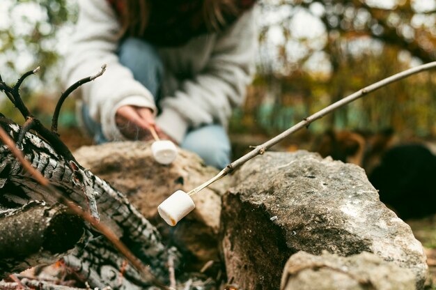 Young woman burning marshmallows