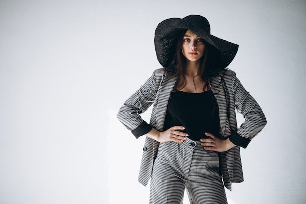 Young woman in a business suit wearing a hat