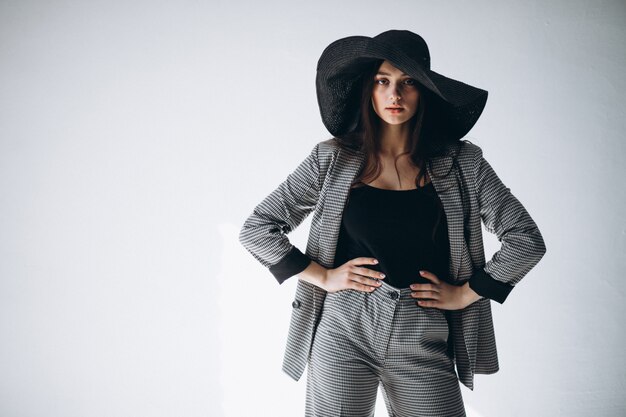 Young woman in a business suit wearing a hat